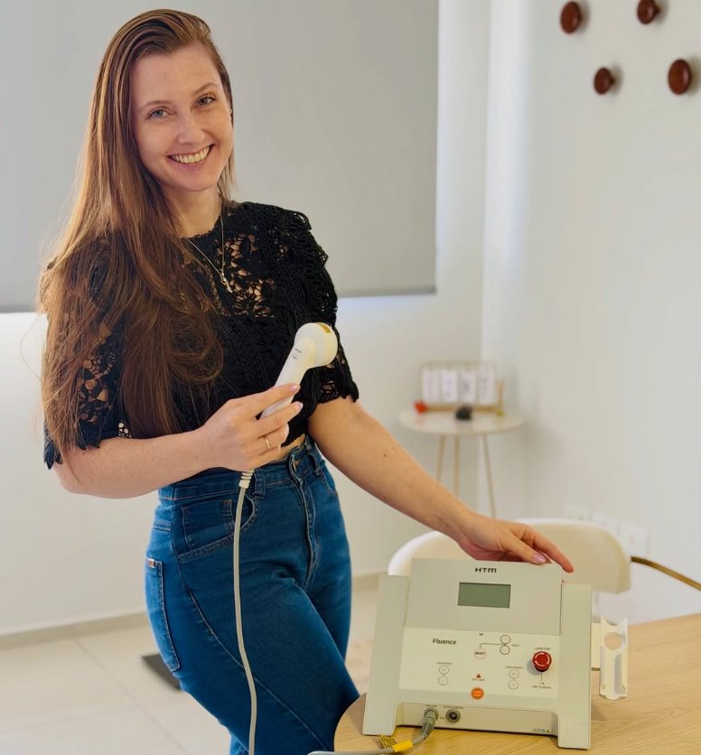 Gisele Tavella ao lado de equipamento de estética